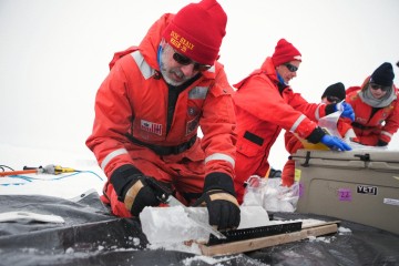 Matt Mills saws  an ice core for the algae at the bottom.